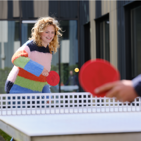 Foto van een deelnemer aan het tafeltennissen in de binnentuin van ICON